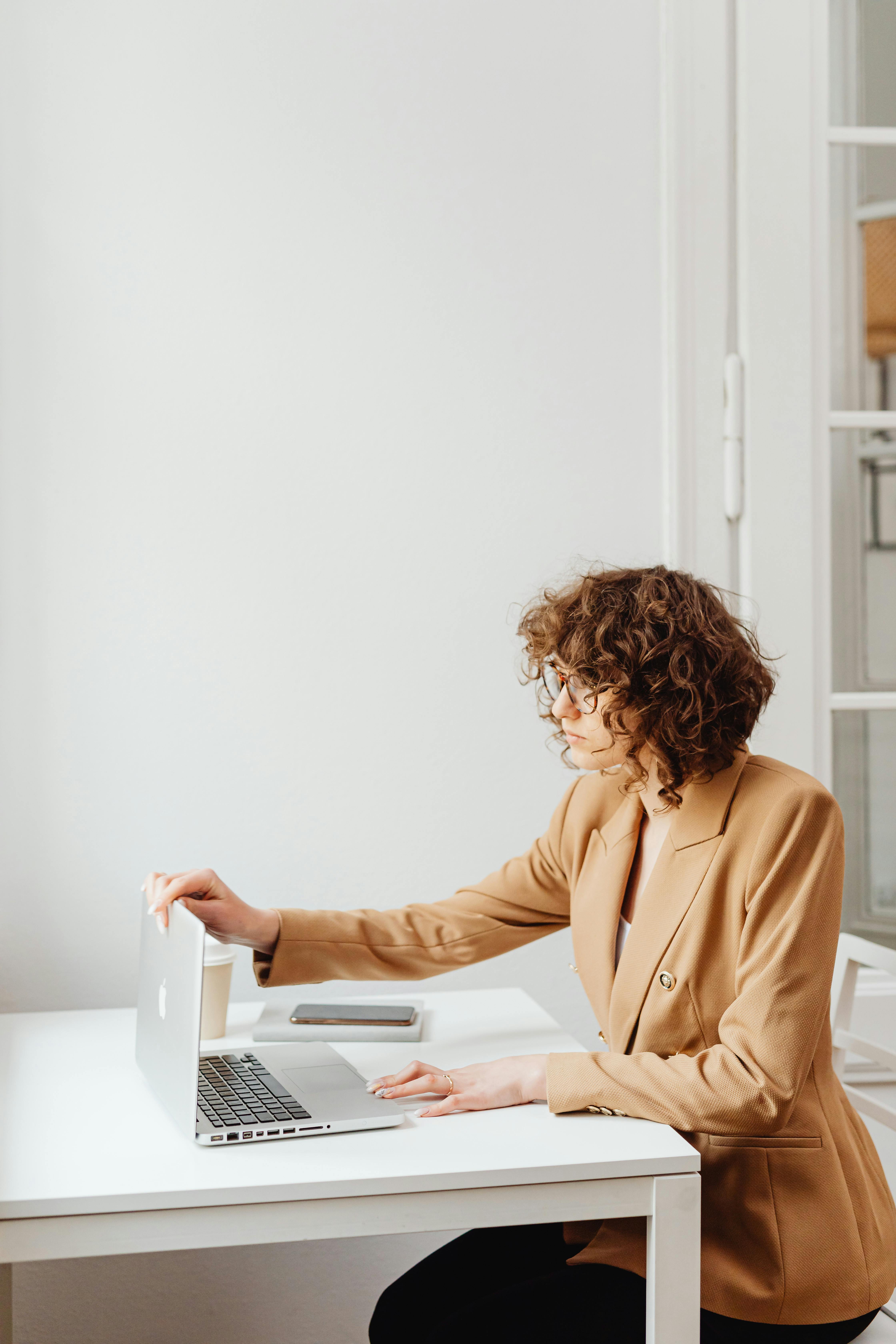 Mujer con blazer trabajando en laptop